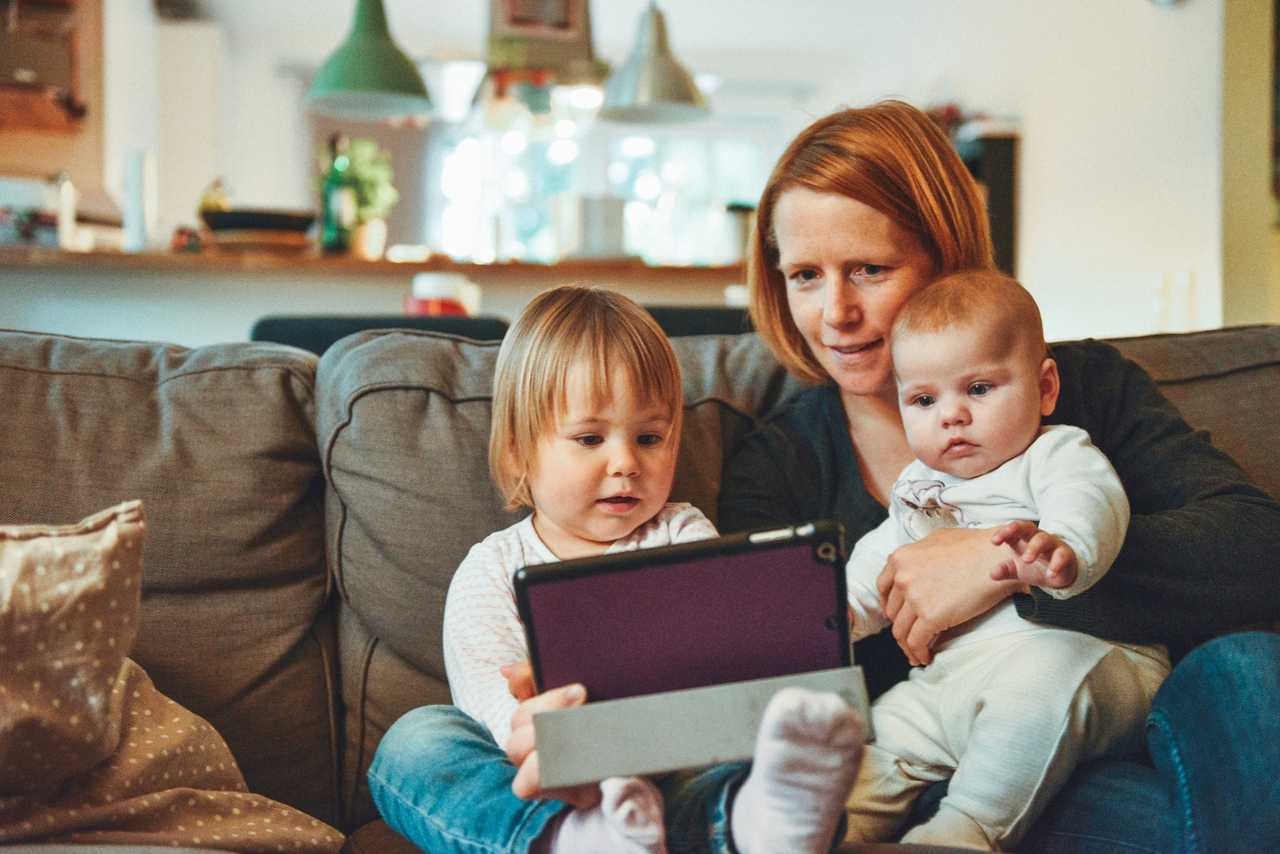 mother and two baby children looking at a table in the couch saying happy mother's day wishes