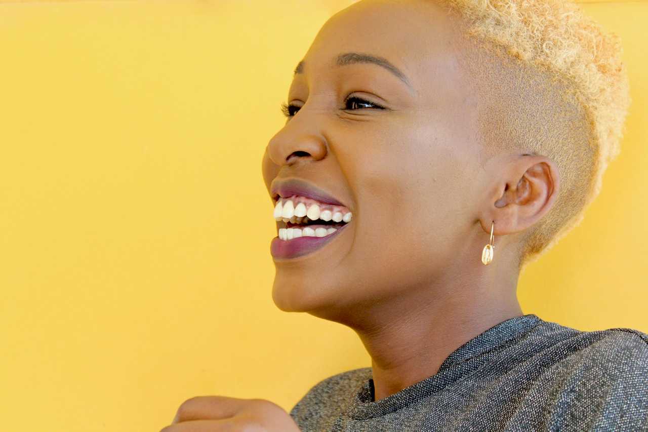 woman smiling over a yellow background happy about getting good morning messages for her