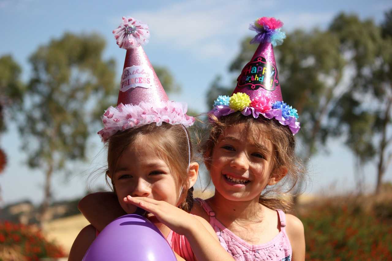 two sisters wearing birthday hats getting birthday wishes