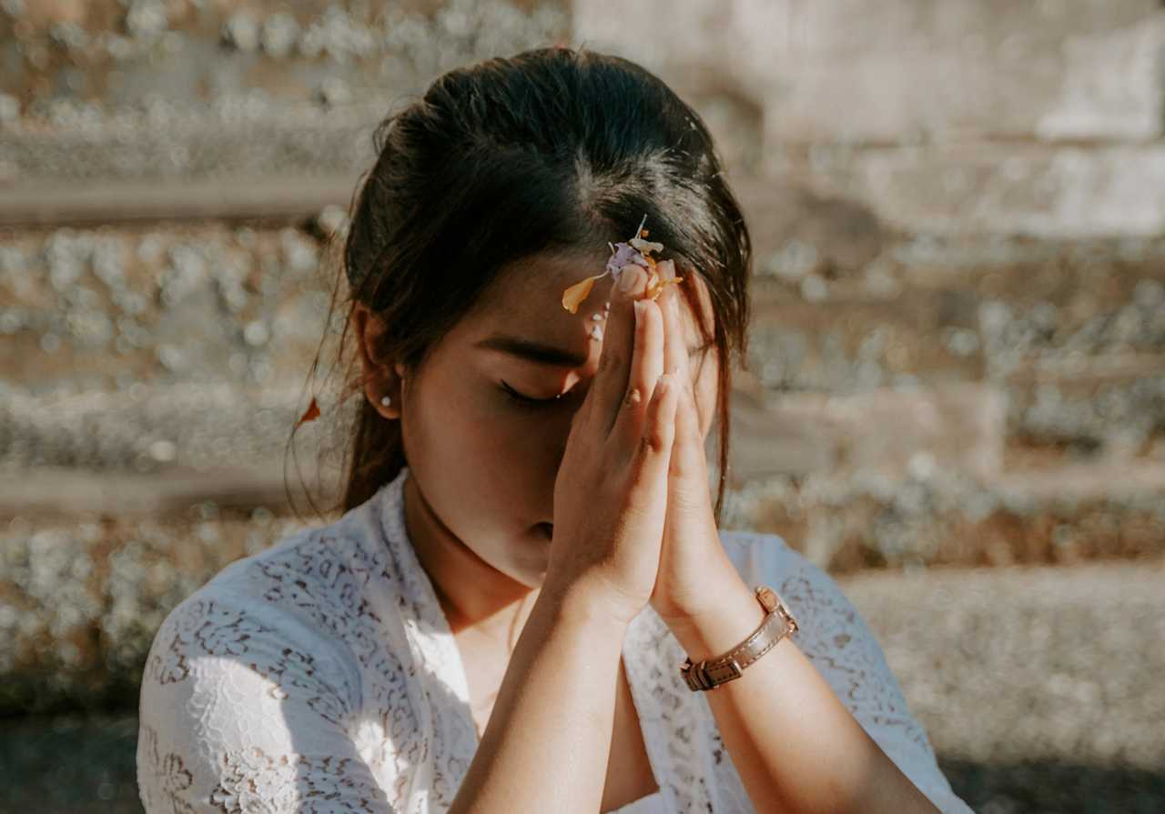 woman praying with hands together over her forehead from ai prayer generator