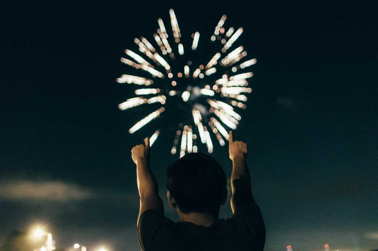 person cheering while there's fireworks in the sky in the new year
