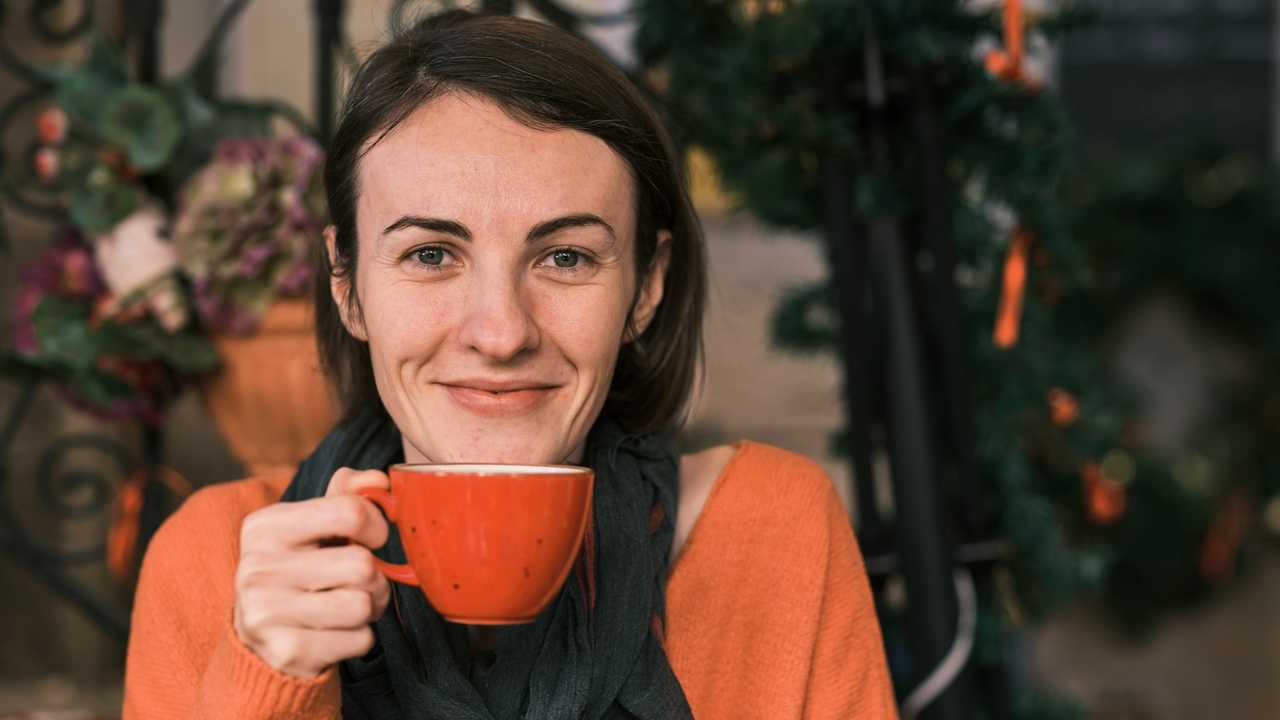 woman grinning holding a cup of coffee getting good morning messages for her