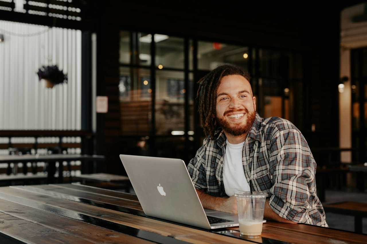 person laughing on a table with his computer after receiving a good ai generated message through Gifft.me