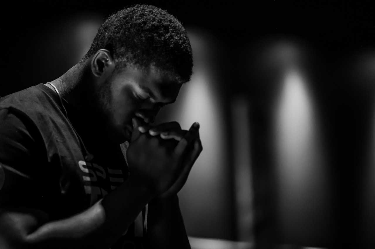 man making an ai generated prayer black and white photo