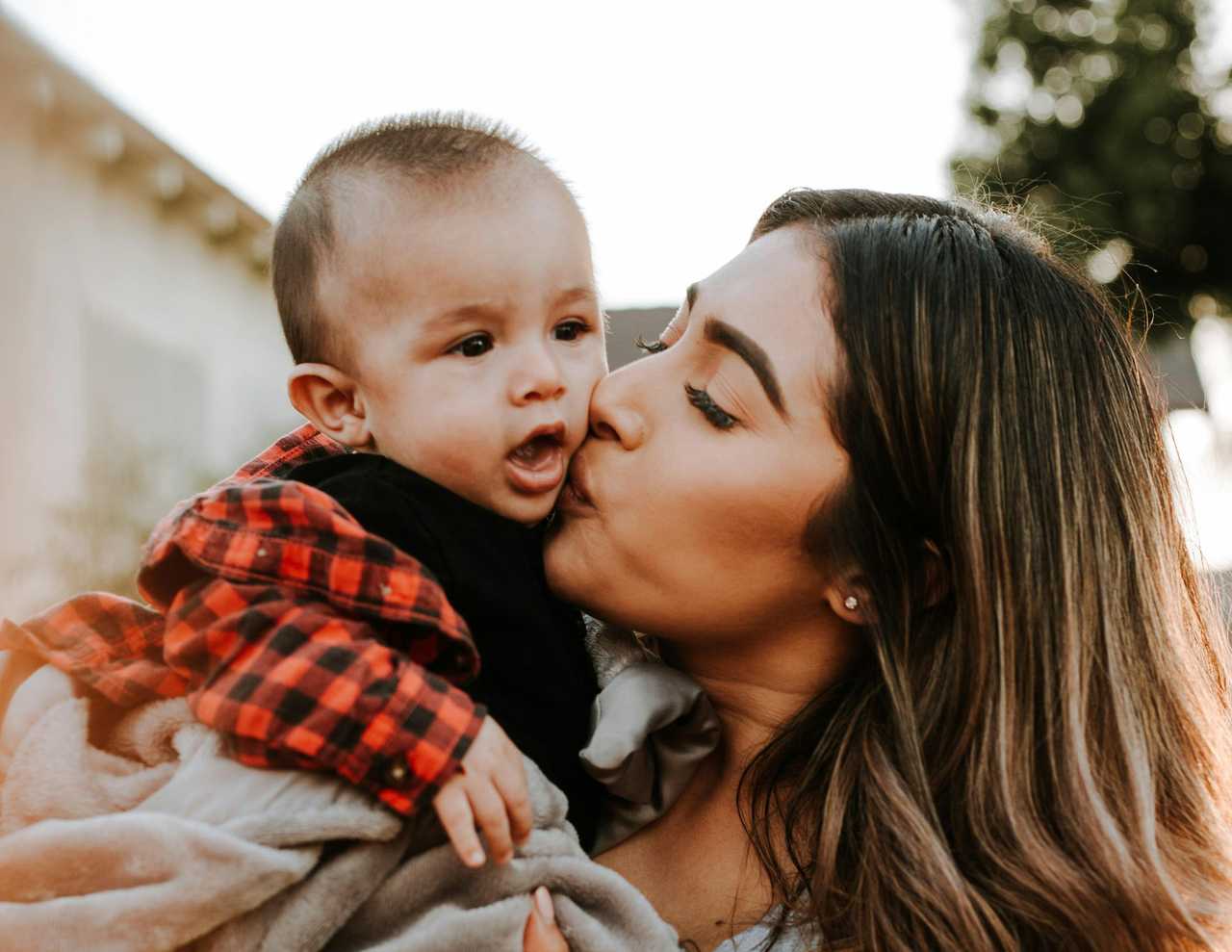 young mom kissing her child in her lap after a good morning mom
