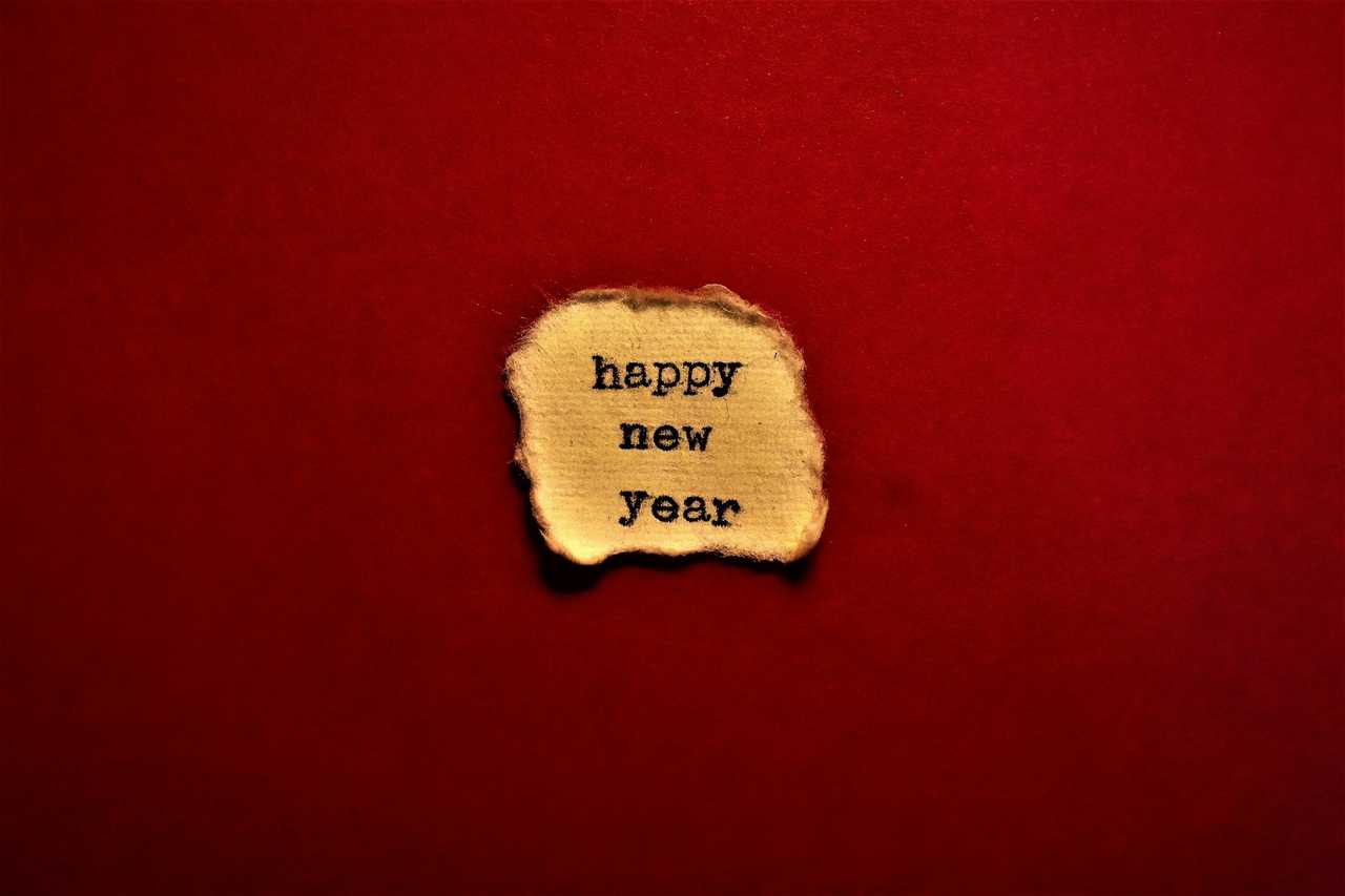 happy new year message on a burnt paper in a red velvet background