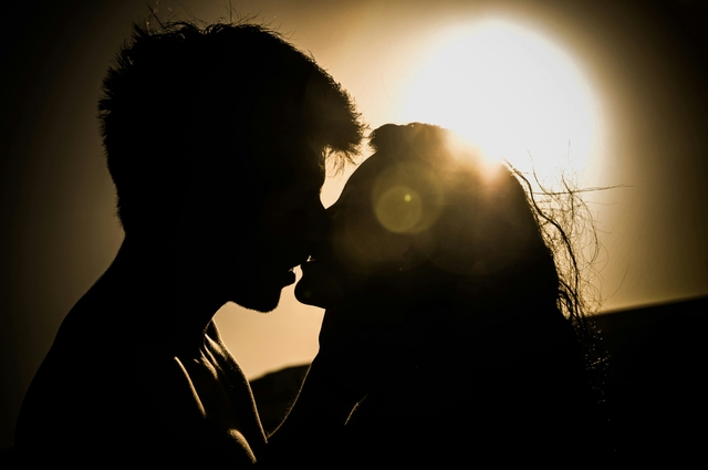 people french kissing with the sun in the background following the first kiss tips