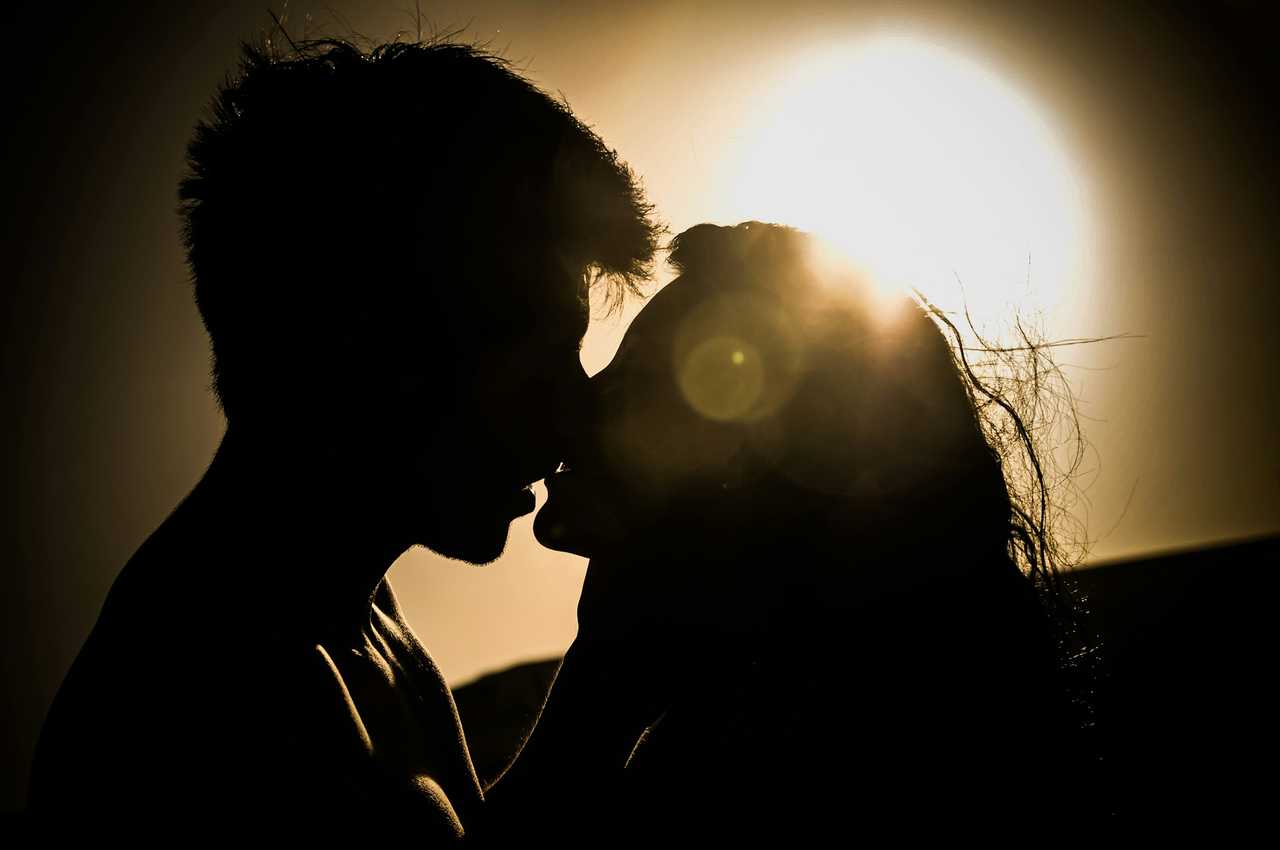 couple kissing for the first time under the sun