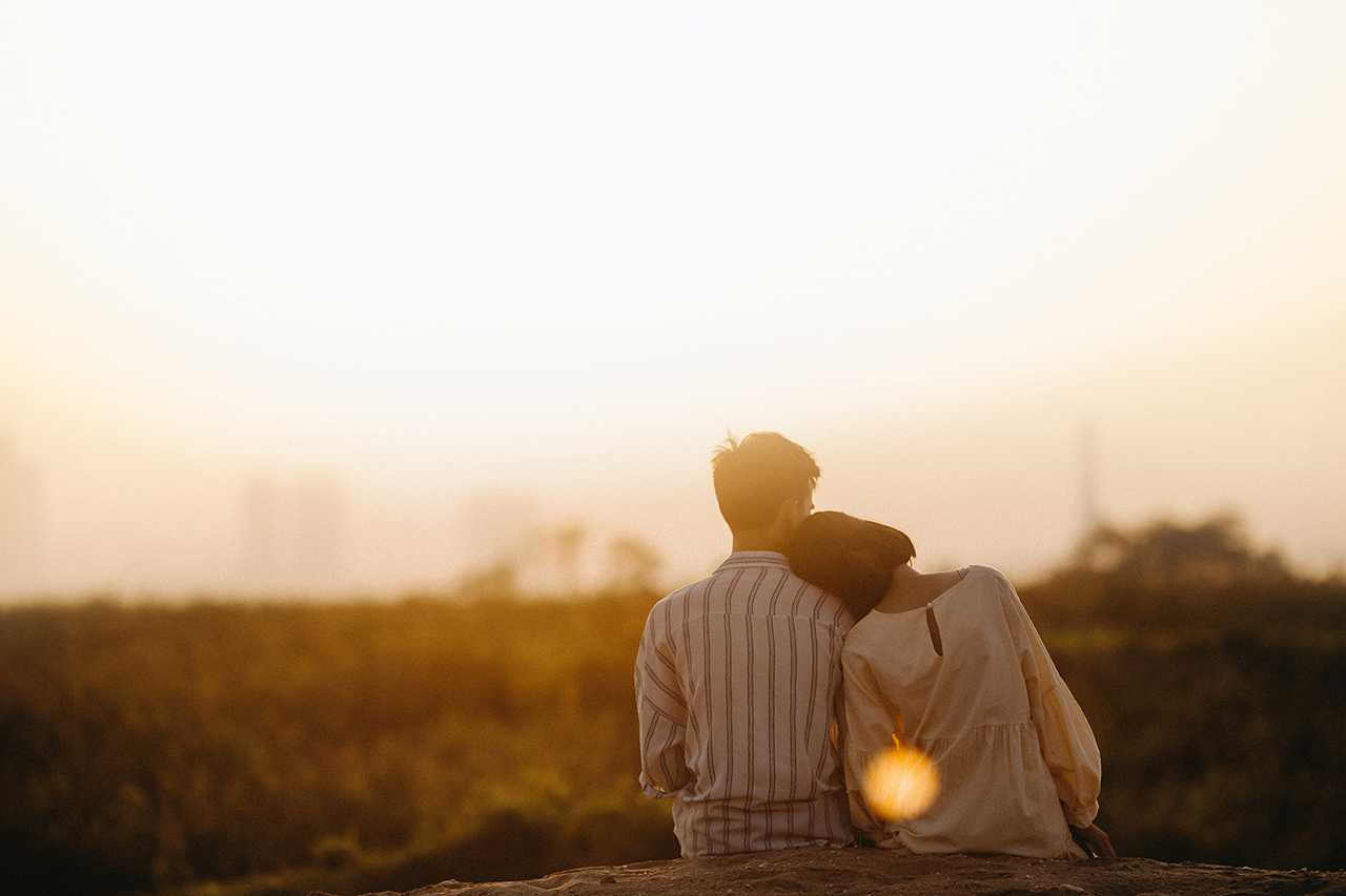 two people snuggling after reading a love poem for him in the golden hour