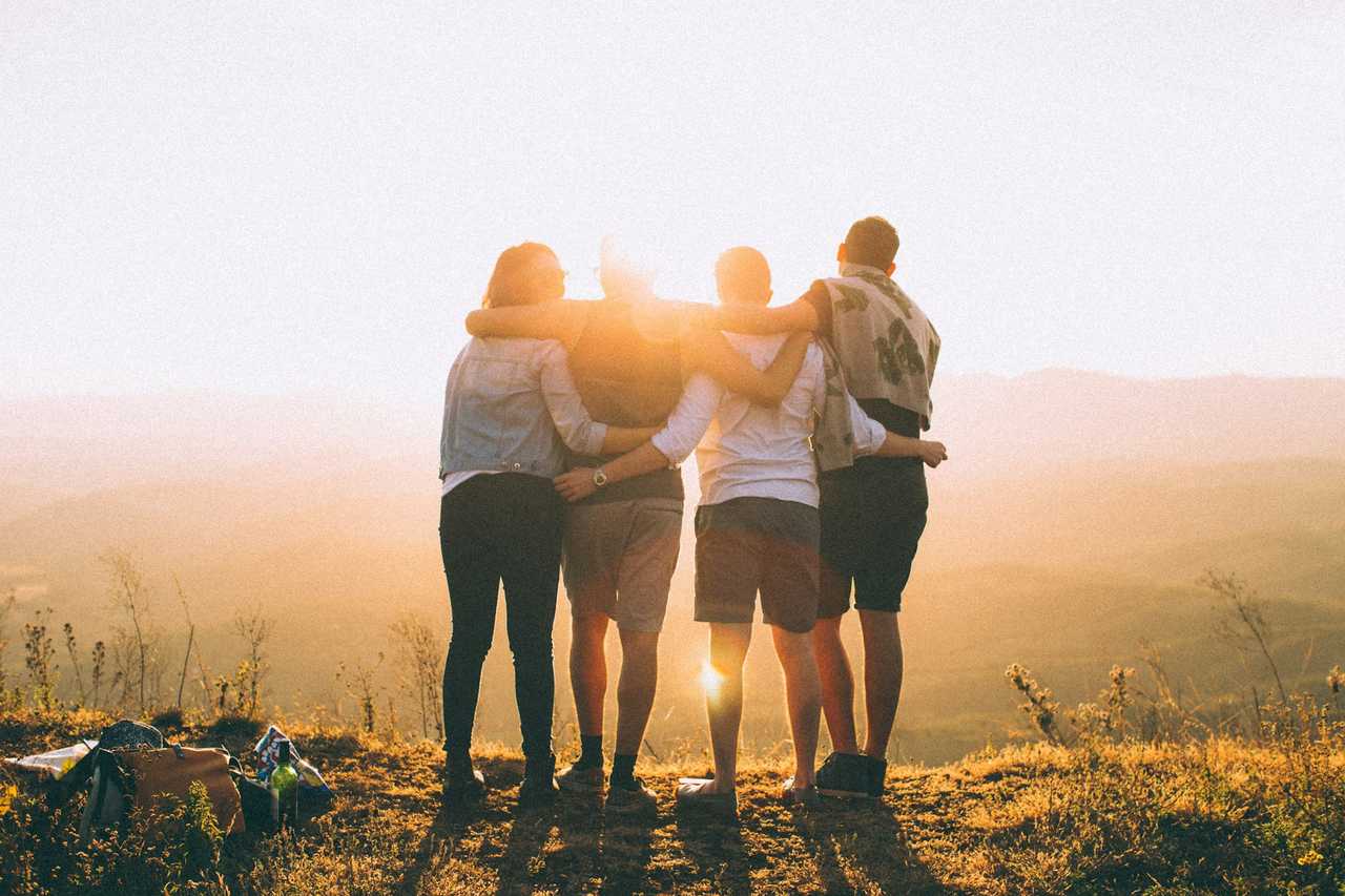 friends together hugging and looking at the sun set in the horizon during Valentine's Day