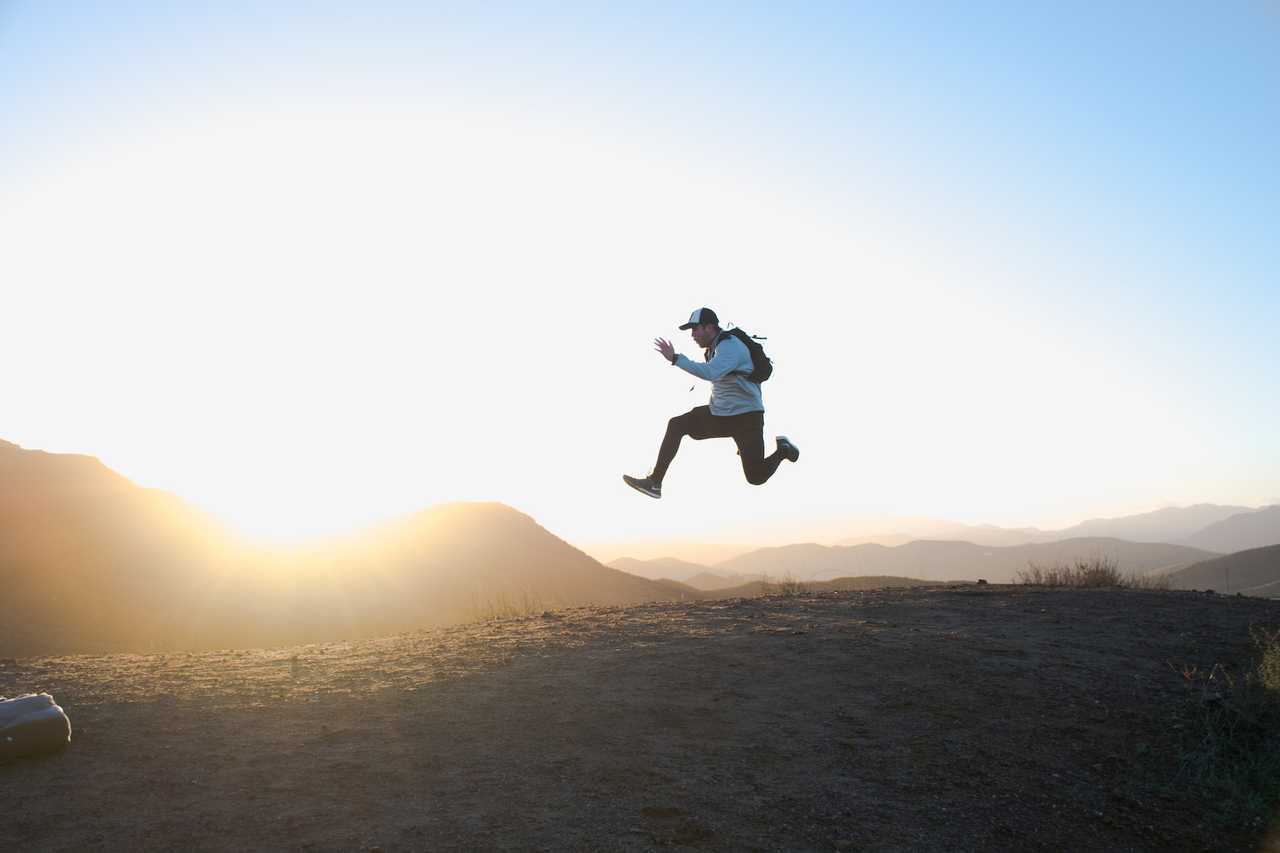 man jumping with the sunset in the background with positive thoughts and reflections