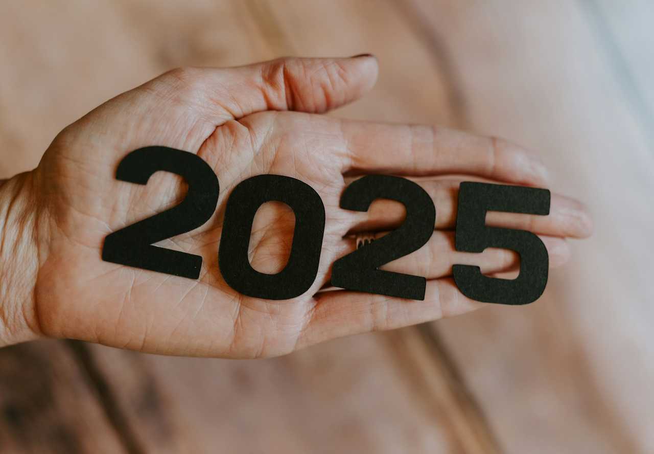 hand holding a 2025 to send with funny new year greetings and messages