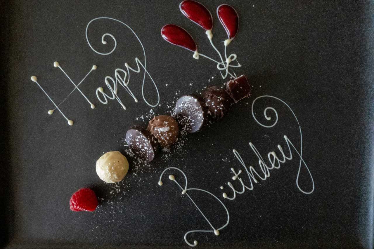 happy birthday message for sister written with chocolate, pralines, and cherries