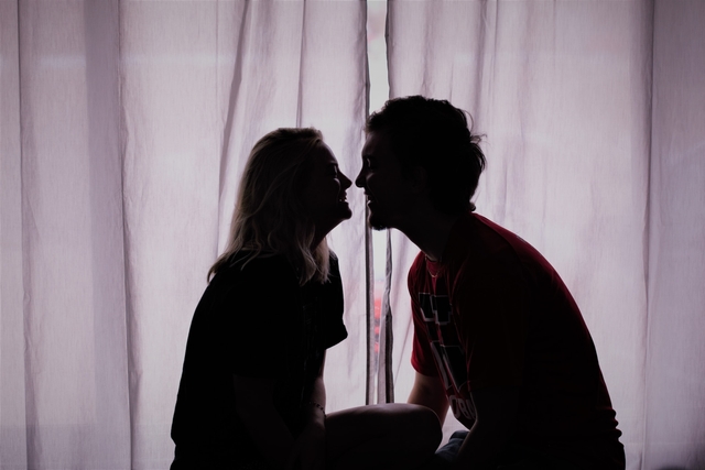 man and woman close to kissing by the window after sending love messages for him