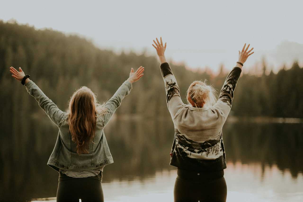 two friends cheering by a lake for the everything else ai messages and greetings generator