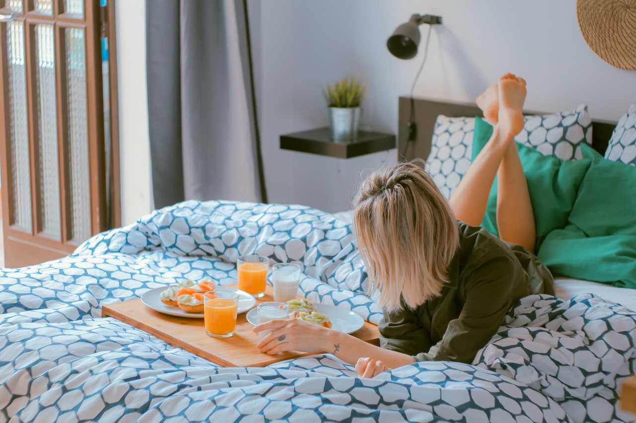 young woman in bed with breakfast in table and good morning sweetheart greeting