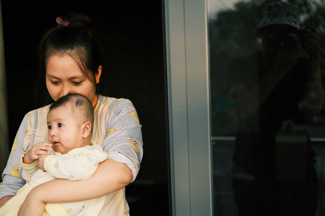 mother holding baby by the door getting happy mother's day
