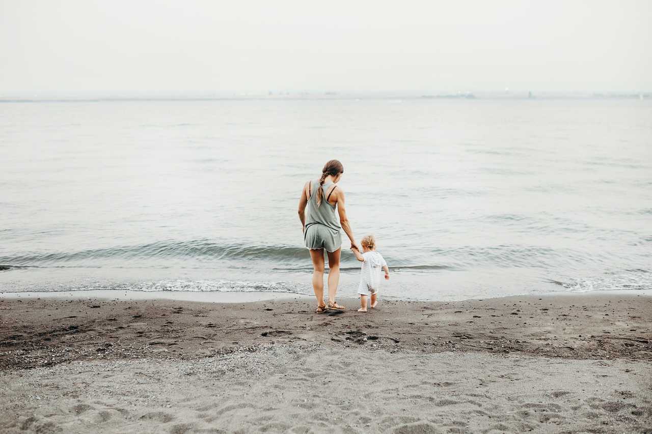 mother and son stepping into the sea in a calm beach happy mother's day wishes