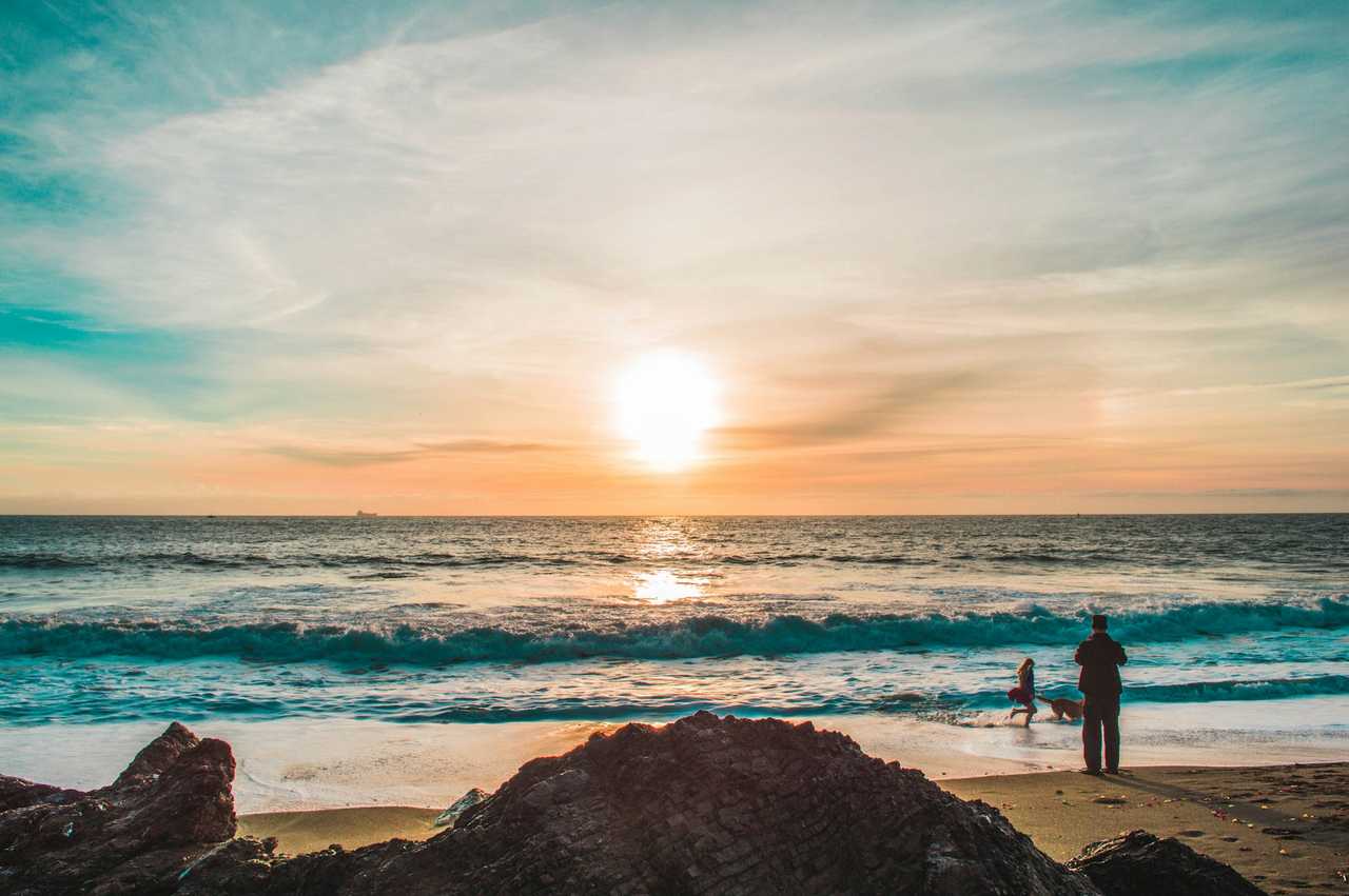 morning sky in the beach with two persons close to the sea saying good morning sweetheart
