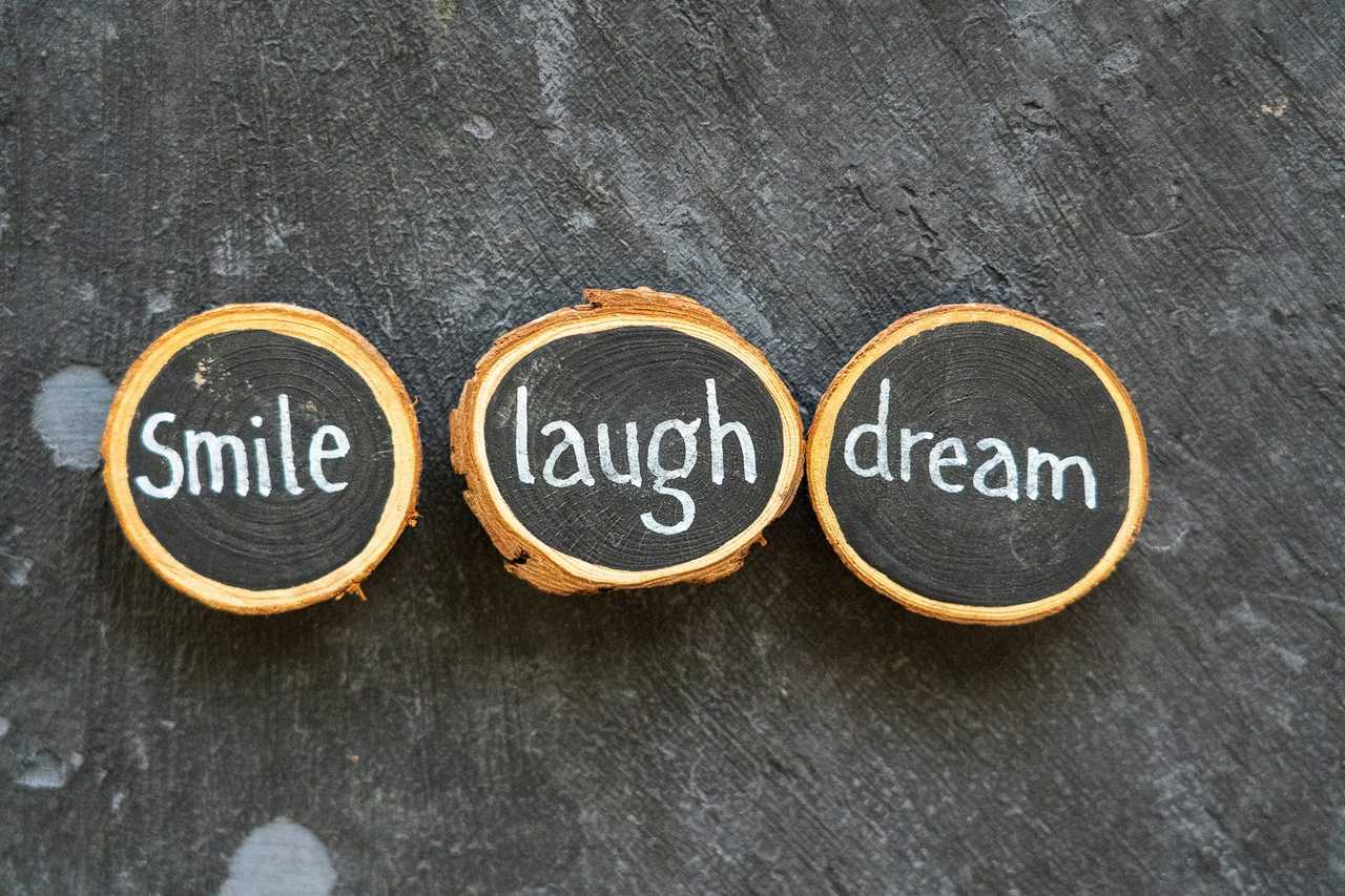 wooden objects with positive messages of the day saying smile laugh and dream