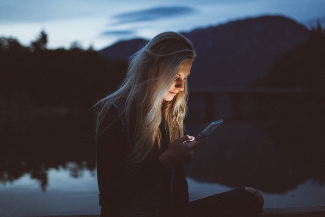 woman sending a good night love message at night by the lake