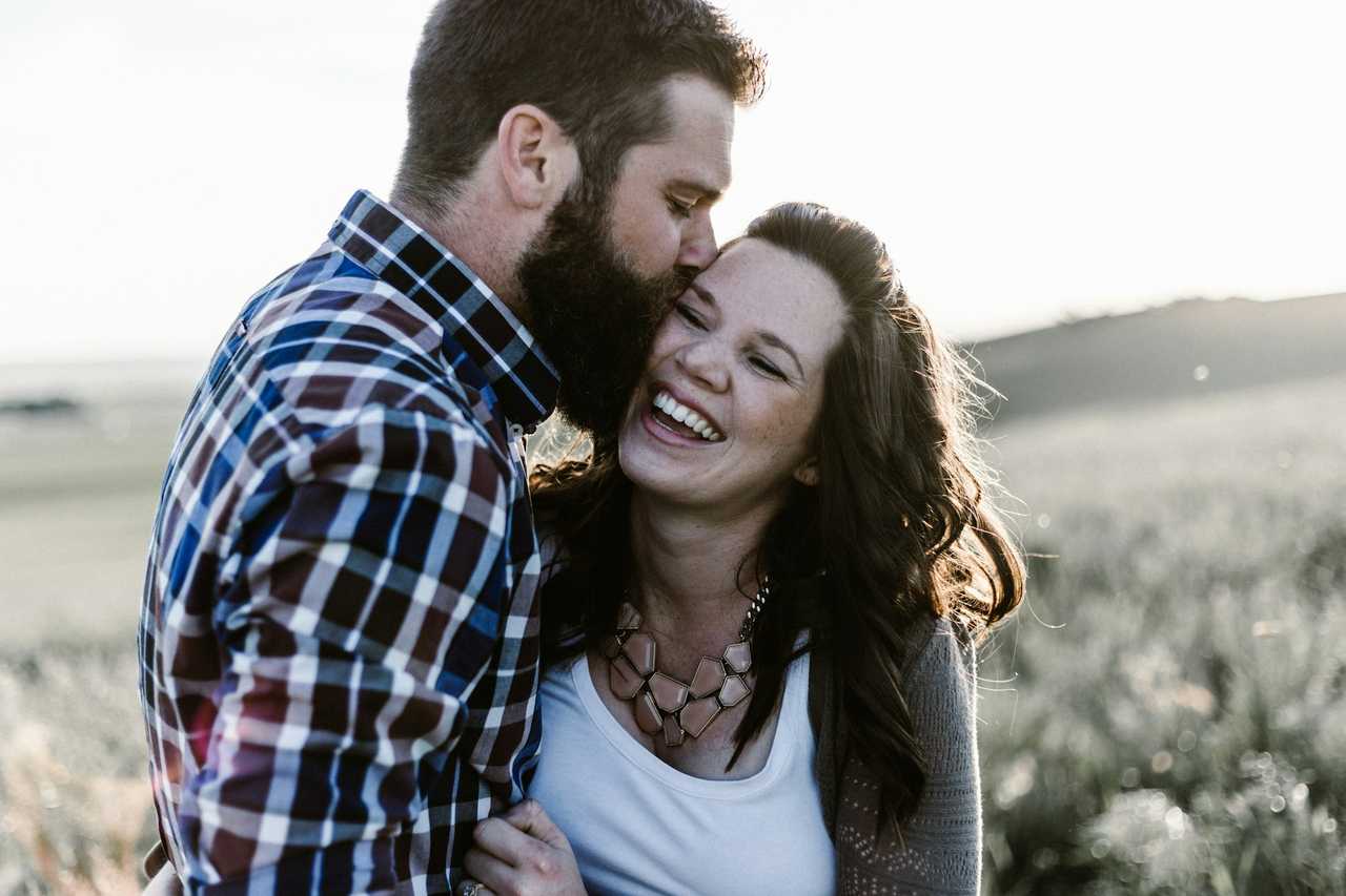 boyfriend kissing girlfriend on the forehead while she smiles on Valentine's Day