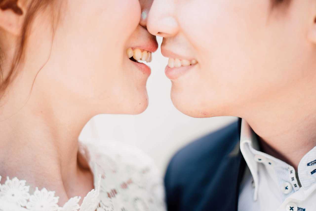 close detail of two person giving their first kiss