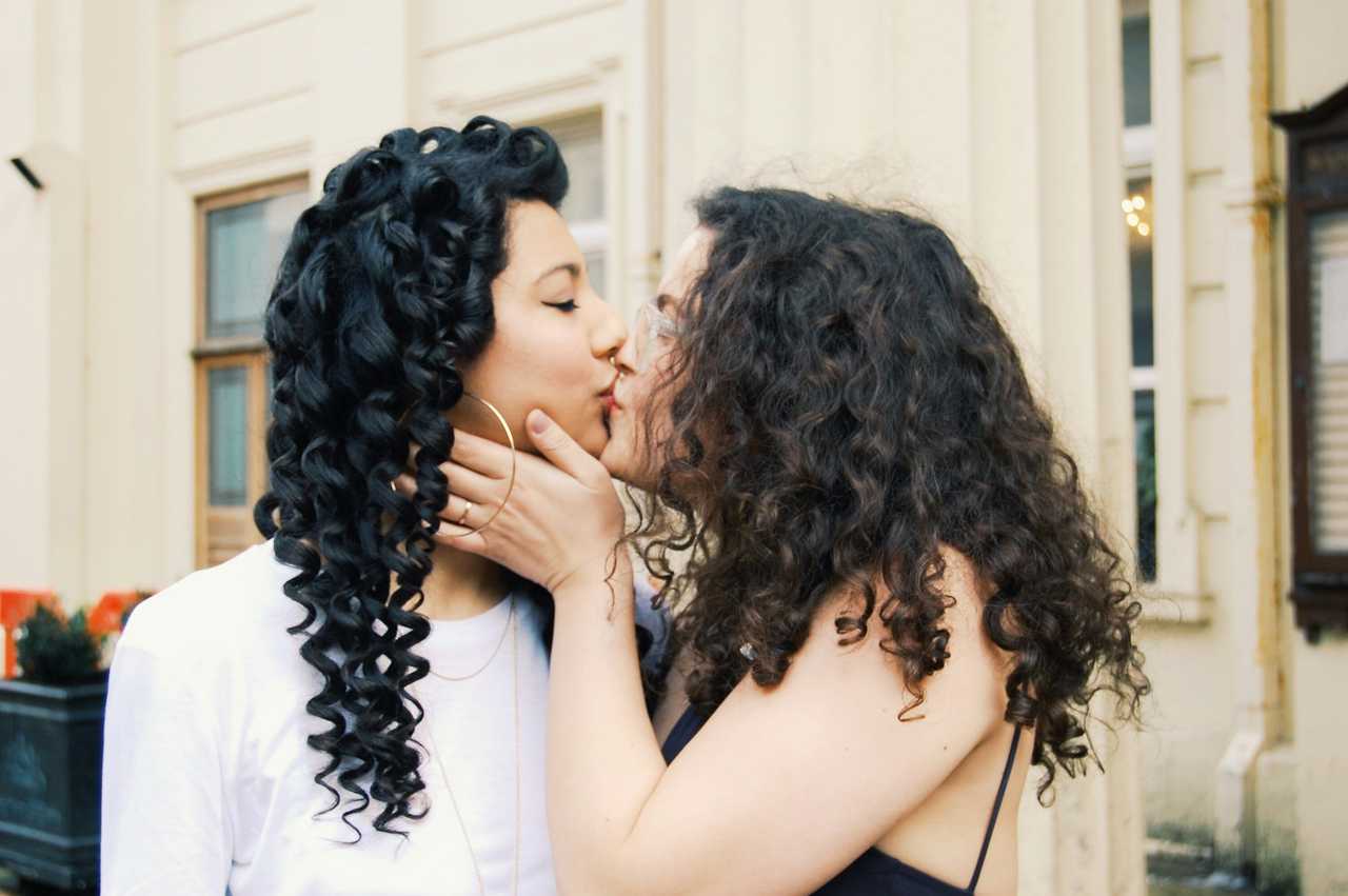 two women kissing at their first date in a charming street