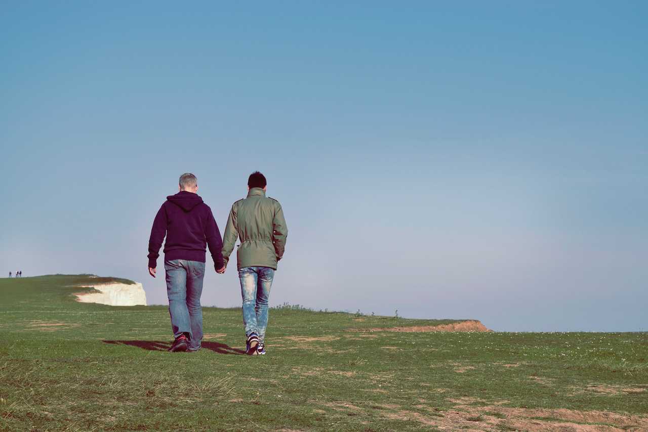couple of boyfriends walking in a cliff saying love messages for him