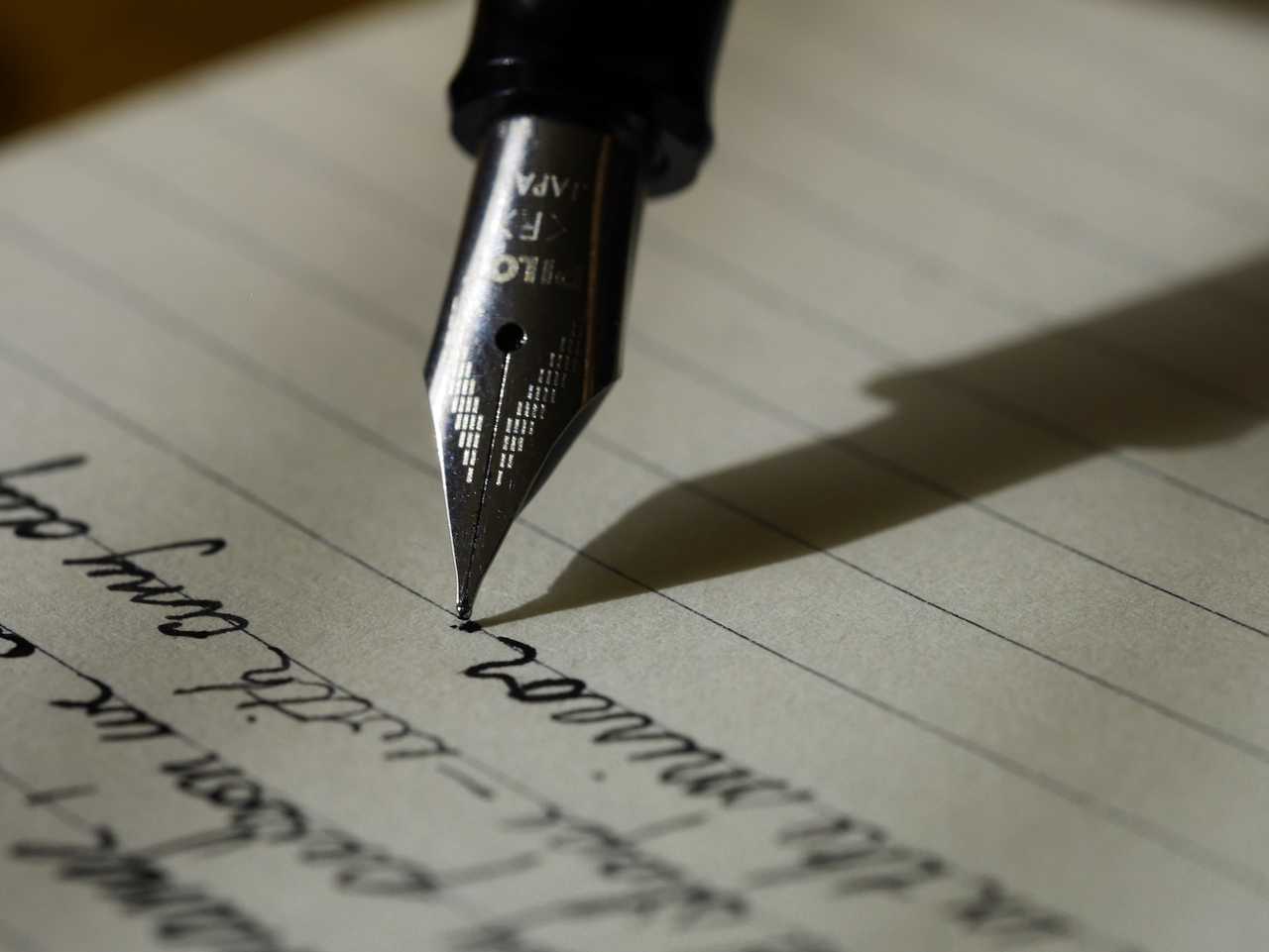 pen writing valentine day wish in a notebook page