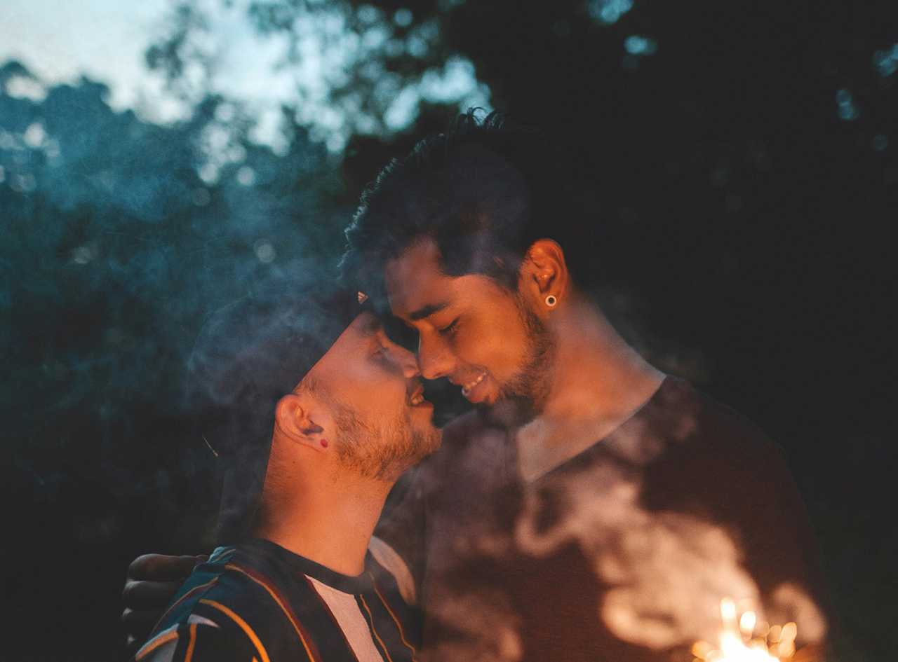 men kissing at the first date at night in a park