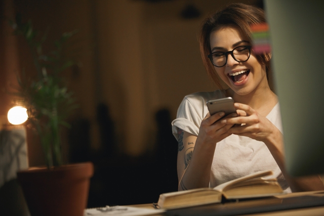 woman seated at night at home sending good night text messages to him