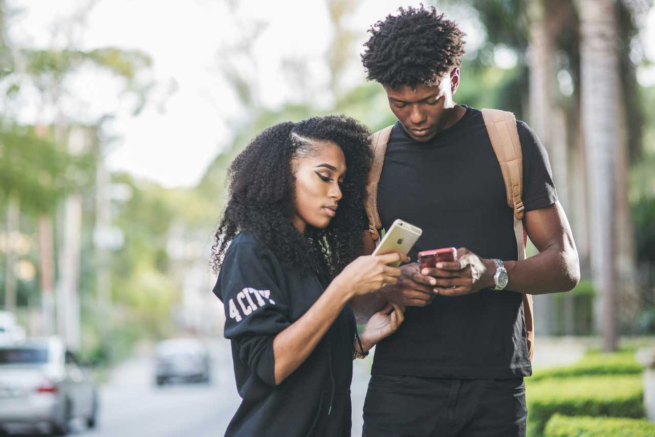 boyfriend and girlfriend checking phones with cute good night texts for him in the street