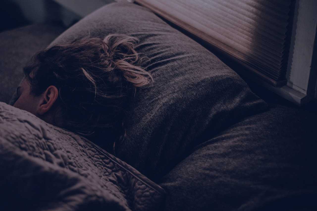 girl sleeping on her side at night in a bed after receiving good night messages from someone special