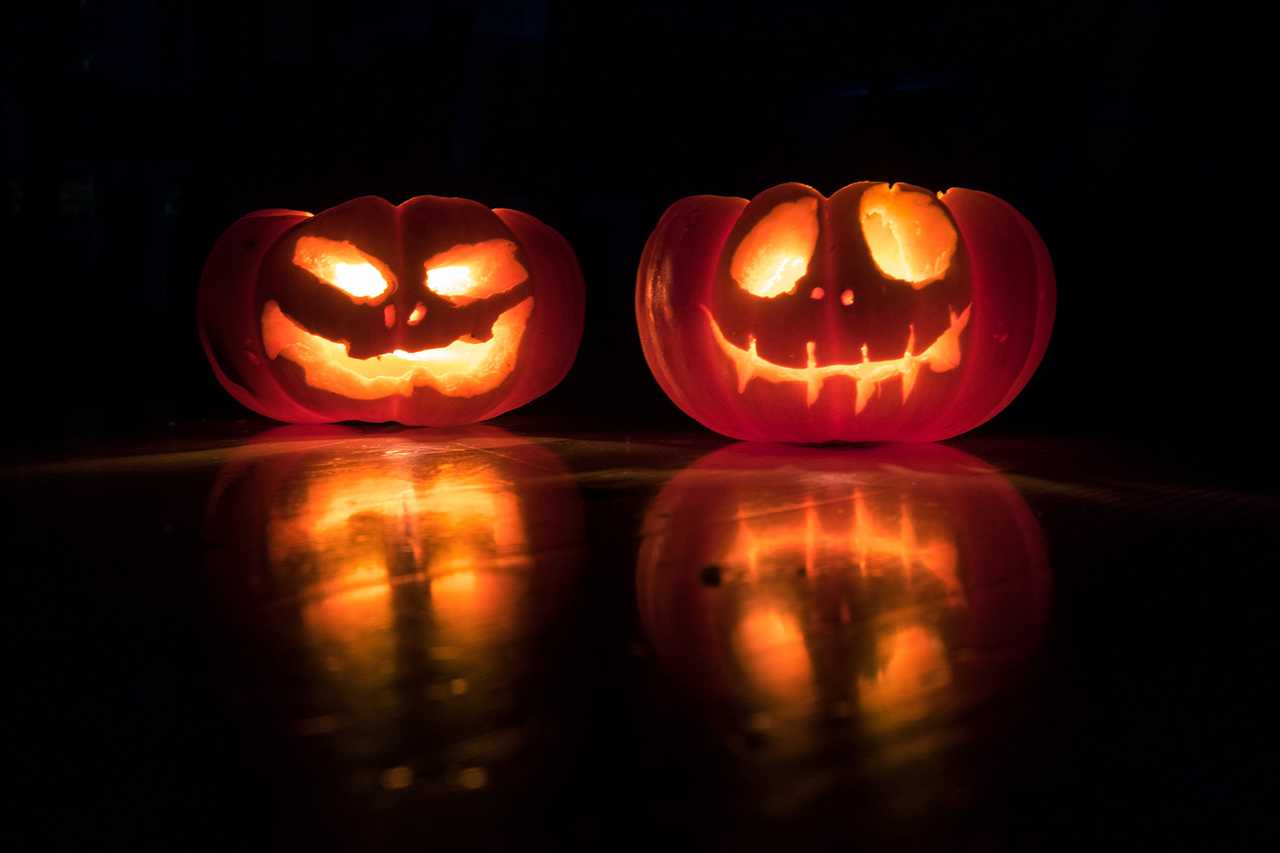 two halloween pumpkins in the dark