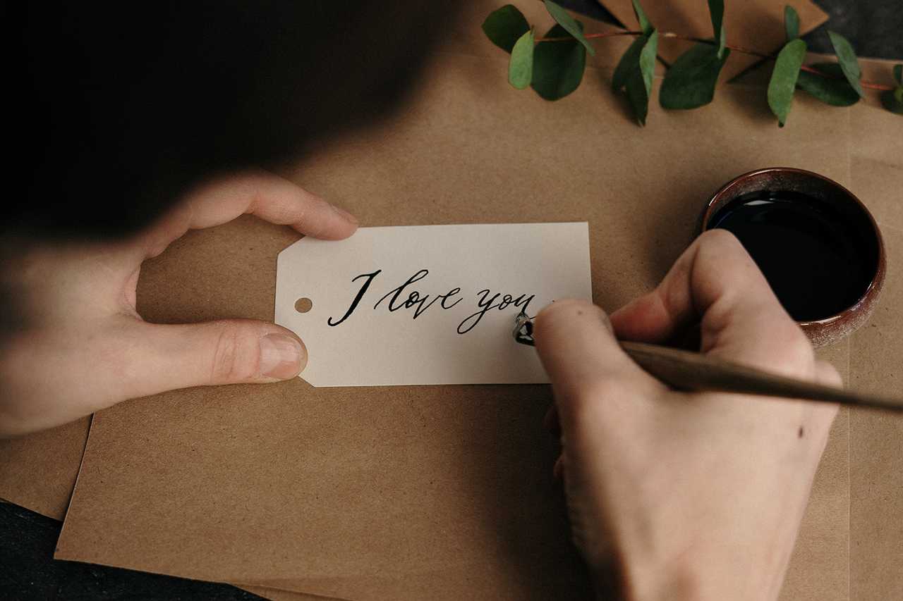 poet writing I love you in a paper label