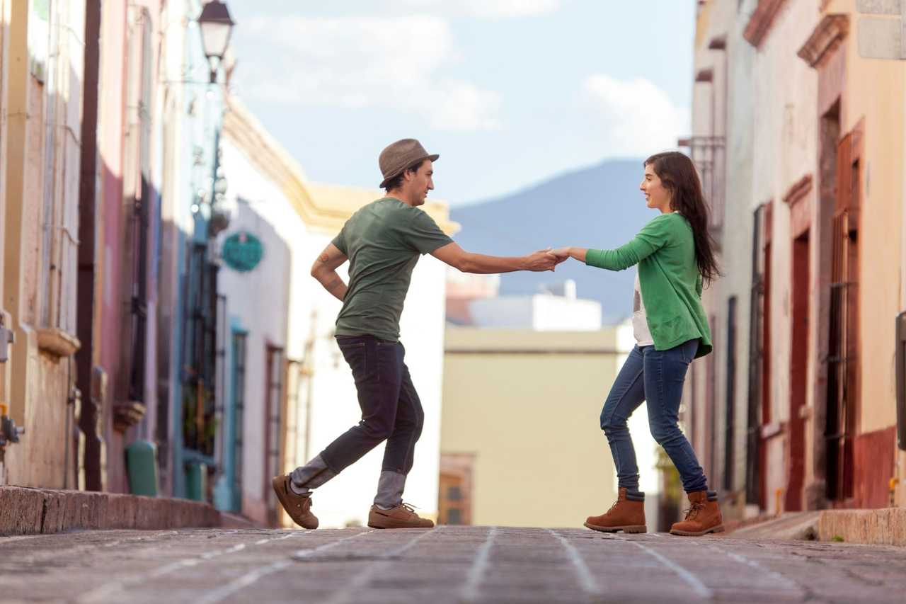 couple walking and dancing in their first date while talking about their favorite things