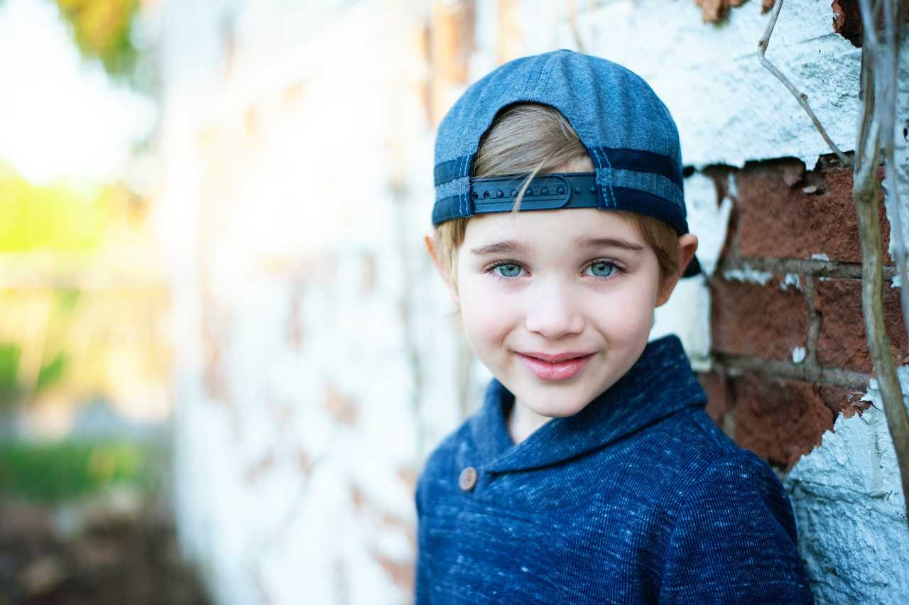 son with a cap by a wall smiling getting i love you son messages from parents