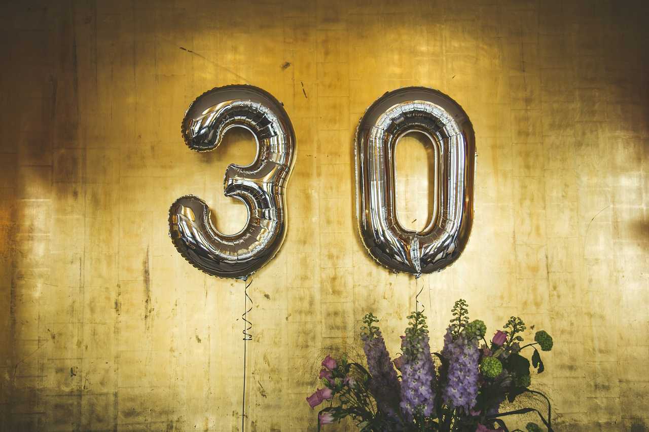 3 and 0 balloons for birthdays hanging from a golden decorated wall
