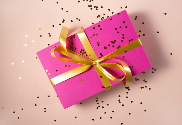 pink gift card on coral background and confetti when to send virtual gift cards