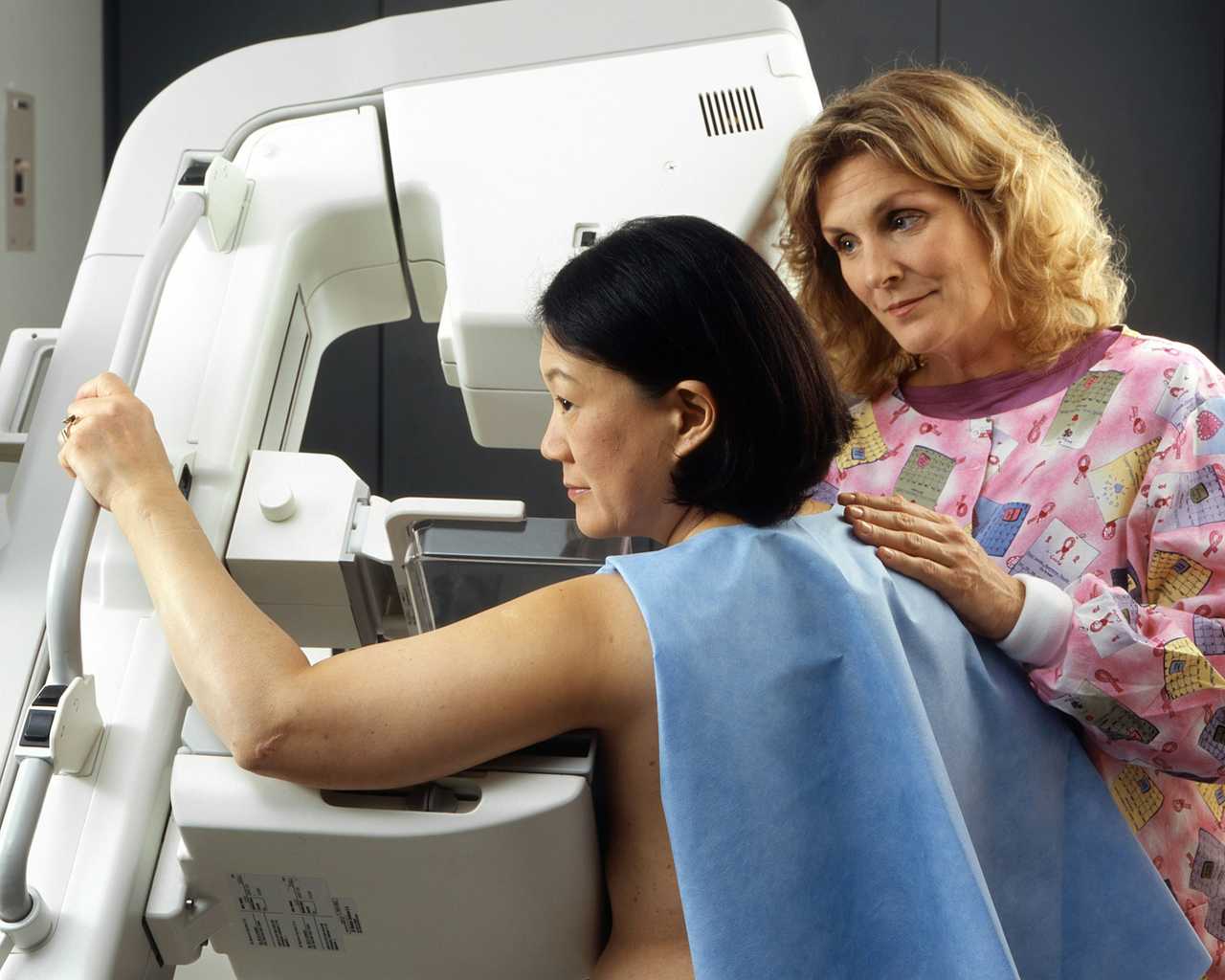 cancer patient doing a mamography accompanied by a nurse