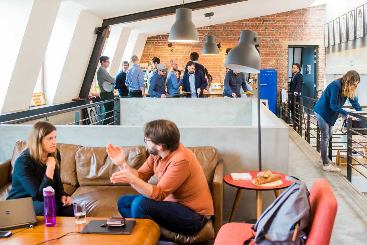 coworkers socializing in the office lounge during a coworker's birthday