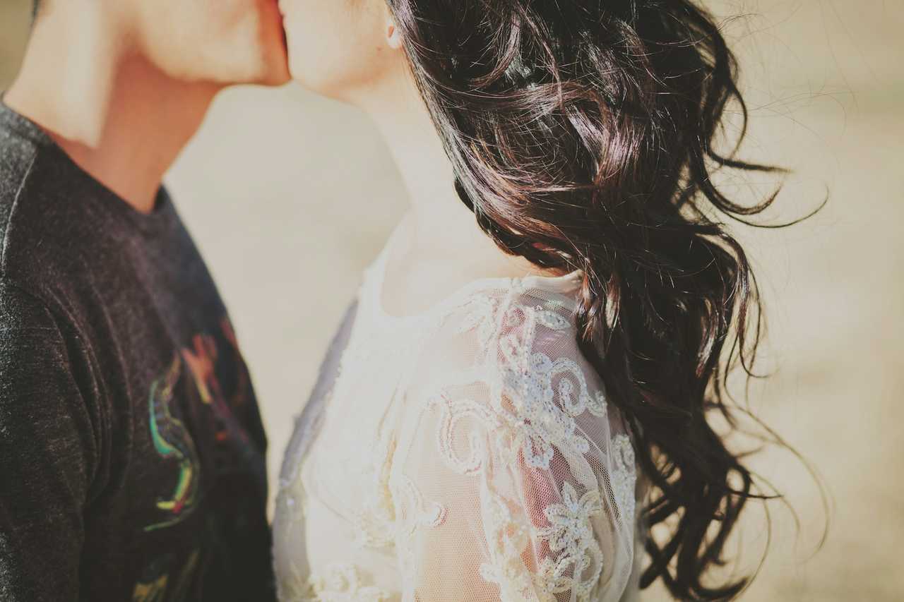 detail of two persons giving their first kiss to each other