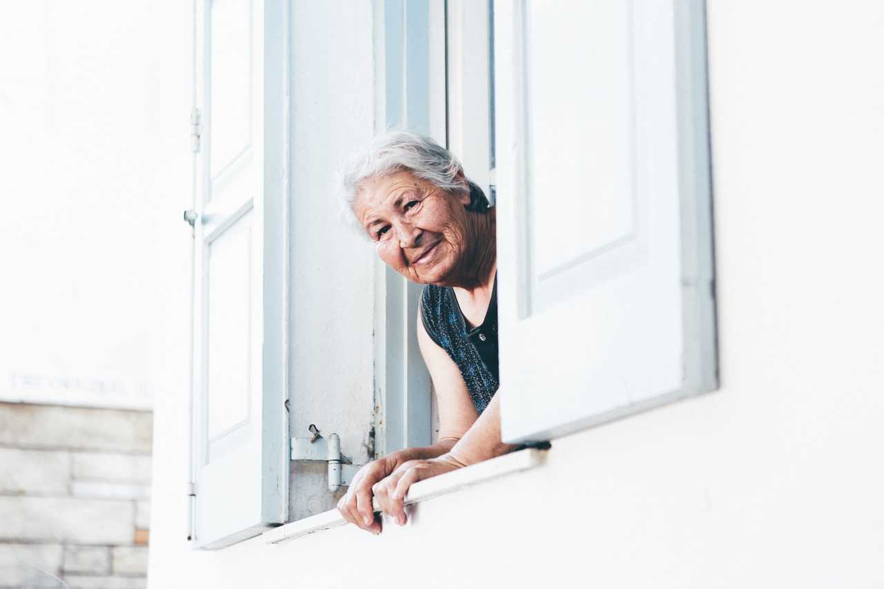 grandmother looking out the window receiving happy mother's day wishes