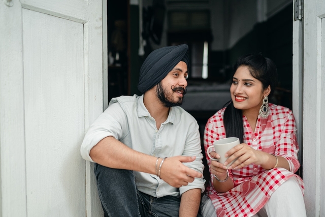 couple sitting in the doorway in the morning wife giving good morning for him