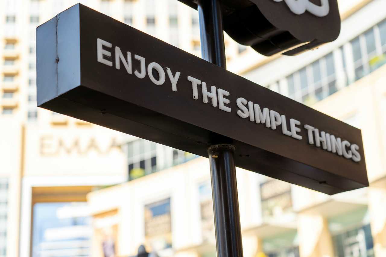 detail of a sign in the street with a positive message about enjoying the simple things