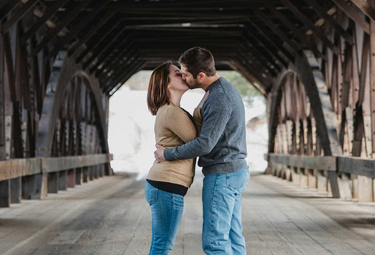 woman and man kissing on a first date in a bridge