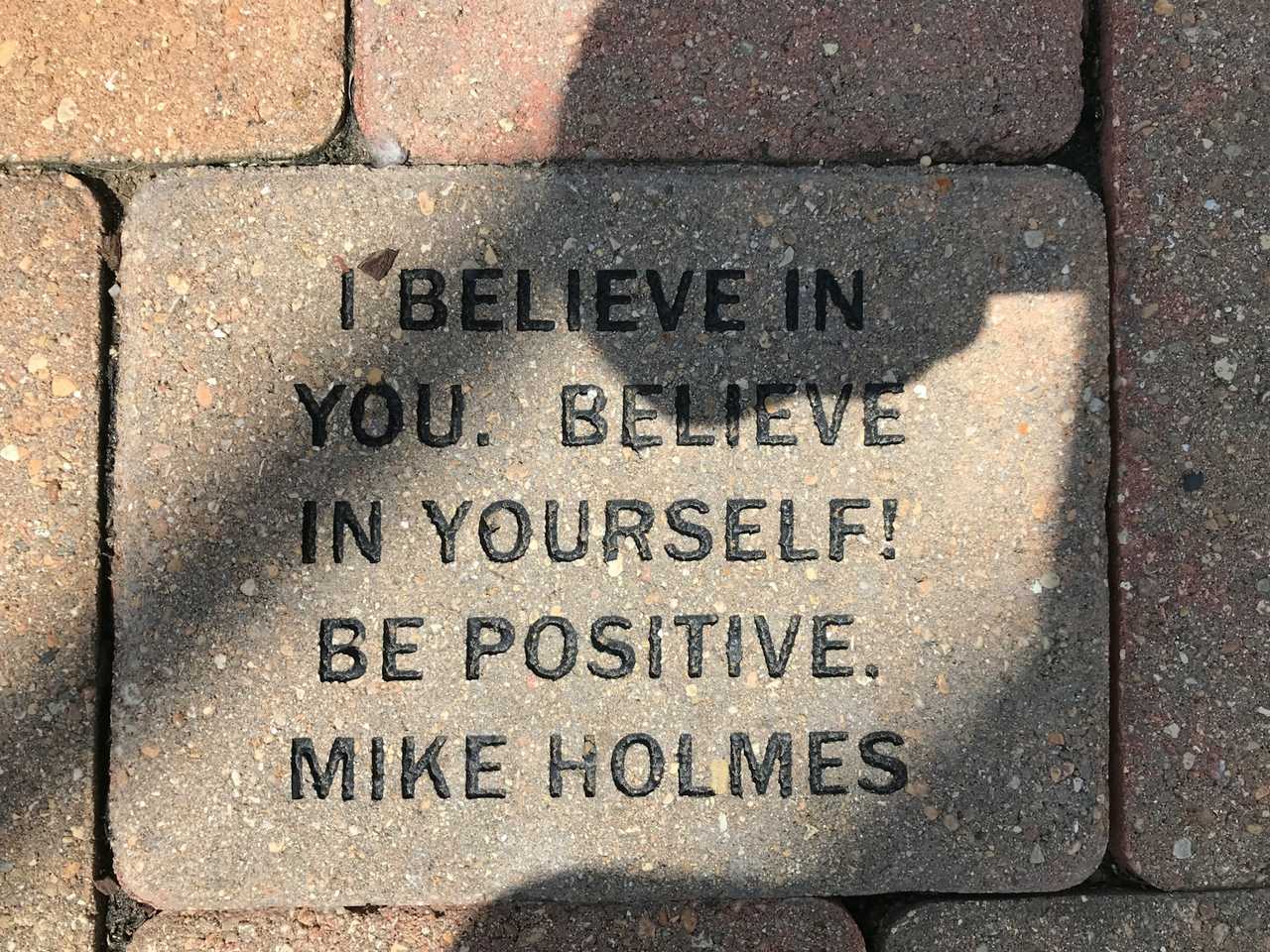 block in the pavement with a positive message of the day with words of believe in yourself