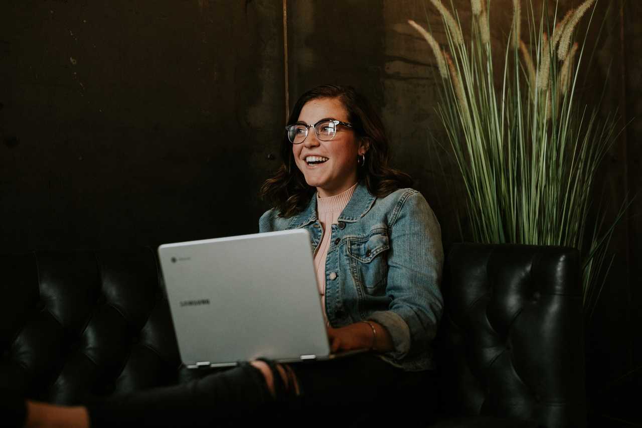 woman receiving an ai-generated compliment by Olivia on her computer and smiling