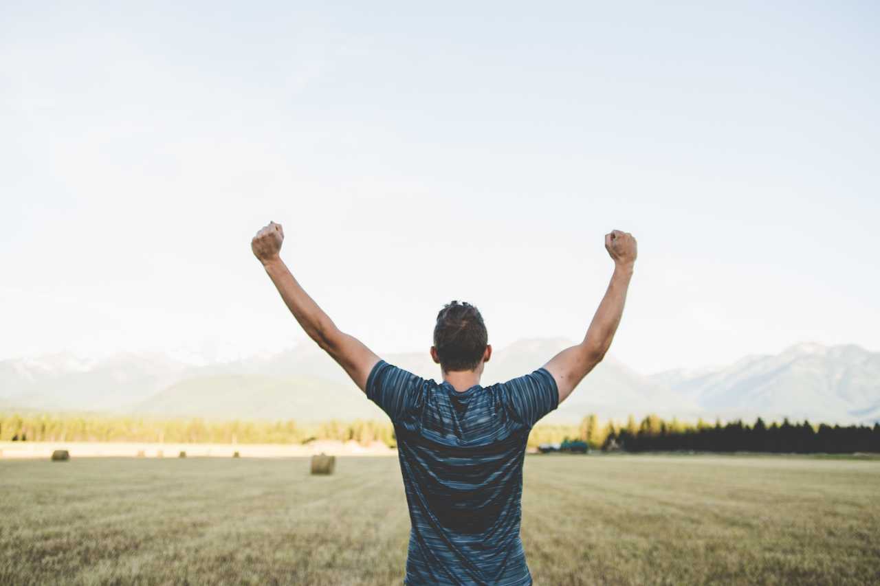 man celebrating with his arms to the sky with positive messages